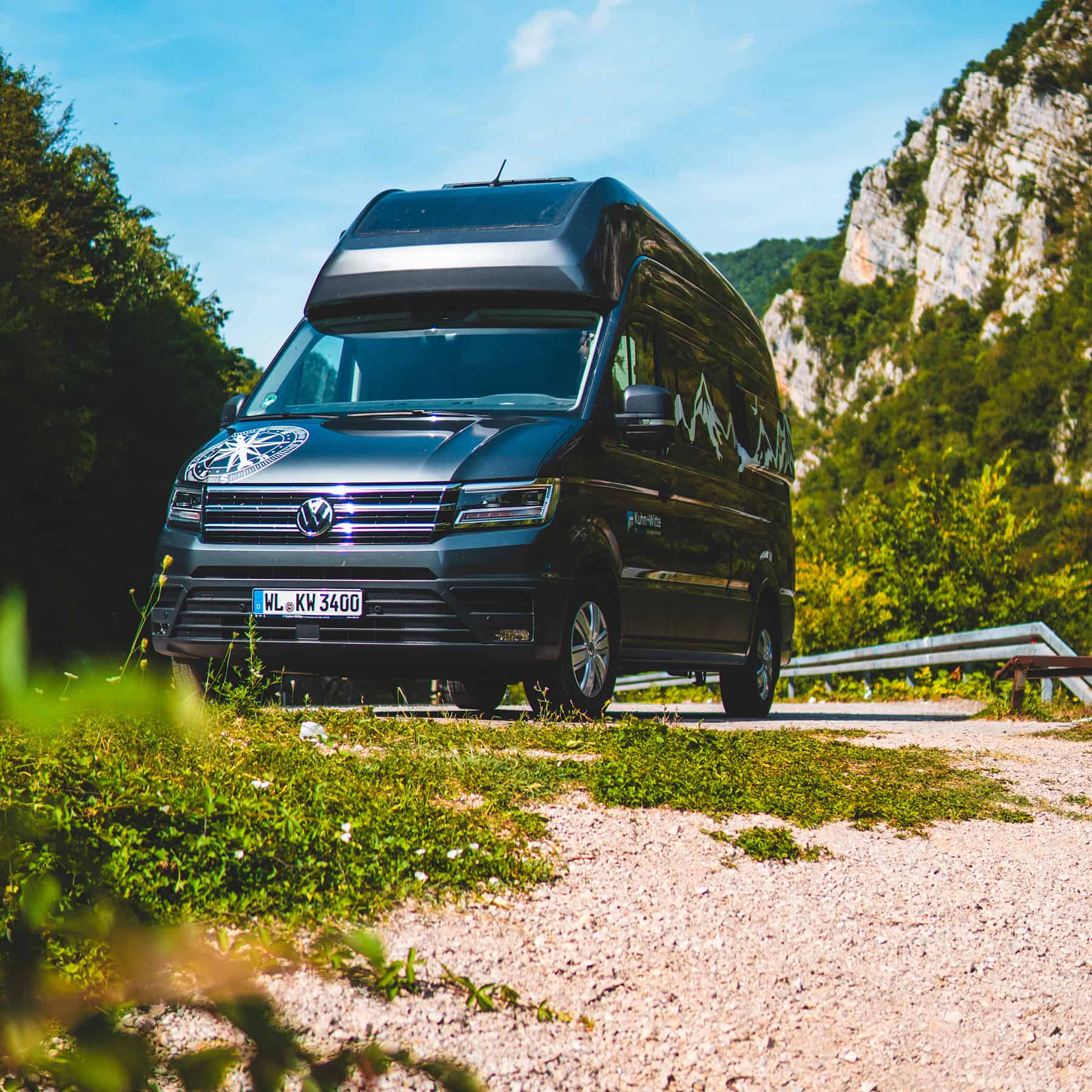 VW Grand California Camper steht in der Natur.