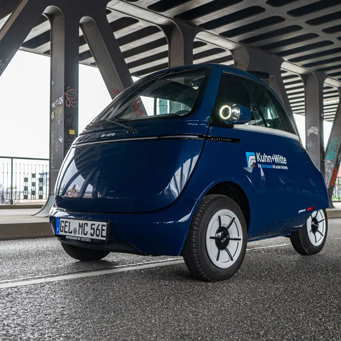 Microlino fährt über eine Brücke.